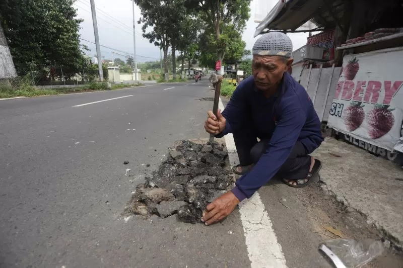 Fan-warga-tambal-lubang-jalan-akibat-pencurian-kanel3JPG-3847175563